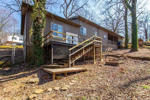 rear view of house with stairs, fence, and a deck