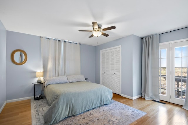 bedroom with baseboards, a ceiling fan, wood finished floors, access to outside, and a closet