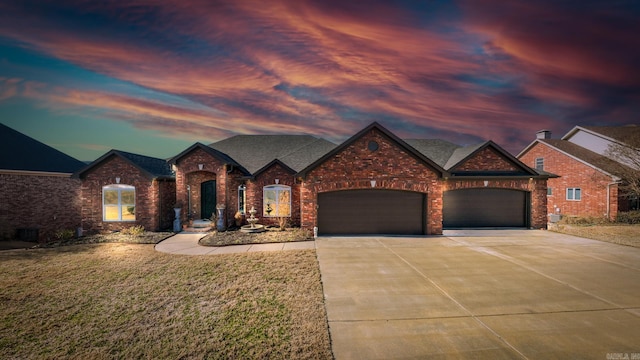 view of front of property featuring brick siding, roof with shingles, a front yard, a garage, and driveway