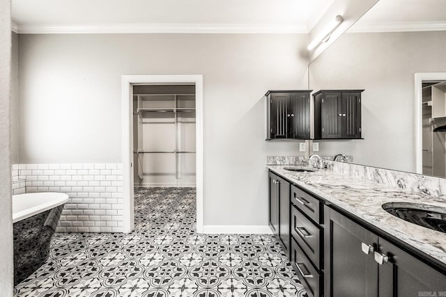 full bath featuring ornamental molding, a soaking tub, and a sink