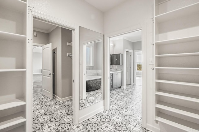 walk in closet with light tile patterned floors