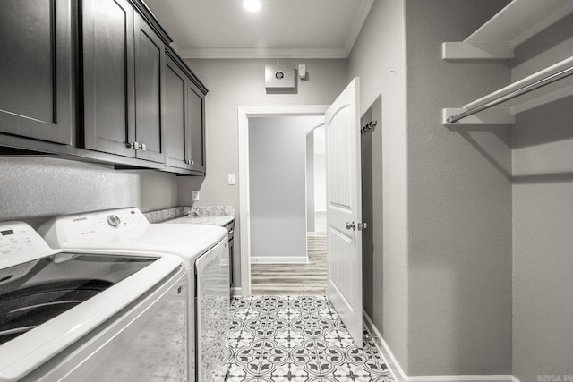 clothes washing area featuring cabinet space, baseboards, ornamental molding, and independent washer and dryer