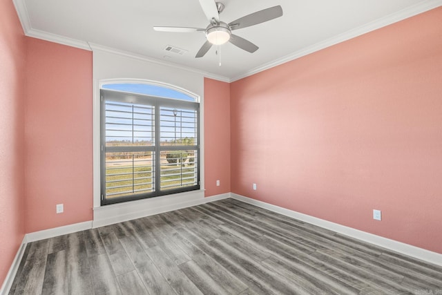 unfurnished room with crown molding, visible vents, a ceiling fan, wood finished floors, and baseboards