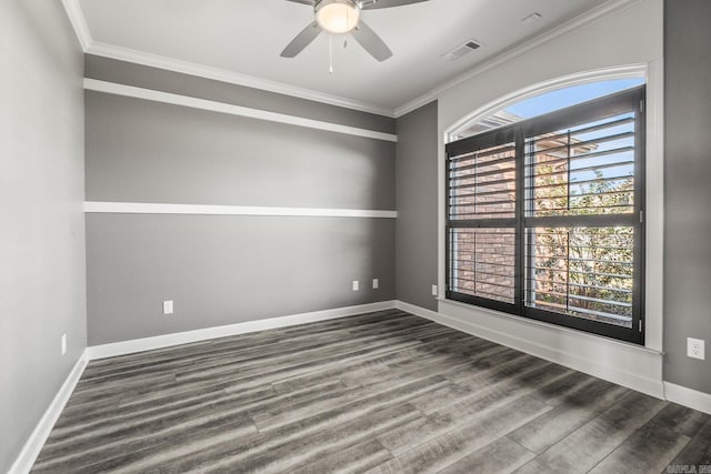 empty room with visible vents, ornamental molding, a ceiling fan, wood finished floors, and baseboards