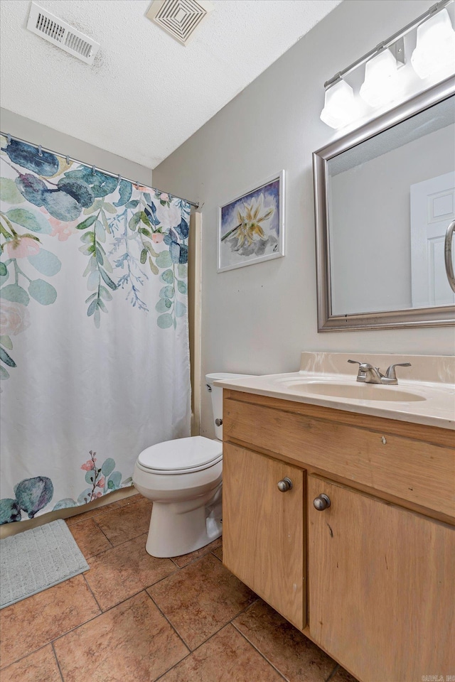 bathroom featuring toilet, visible vents, a textured ceiling, and vanity