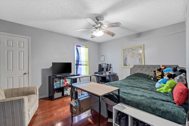 bedroom with hardwood / wood-style flooring, ceiling fan, and a textured ceiling