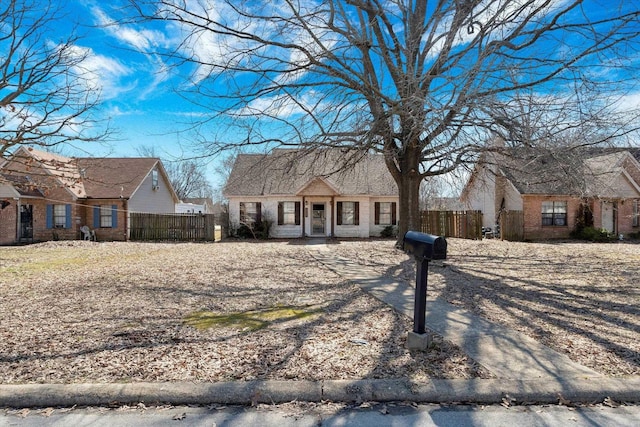 view of front facade featuring brick siding and fence