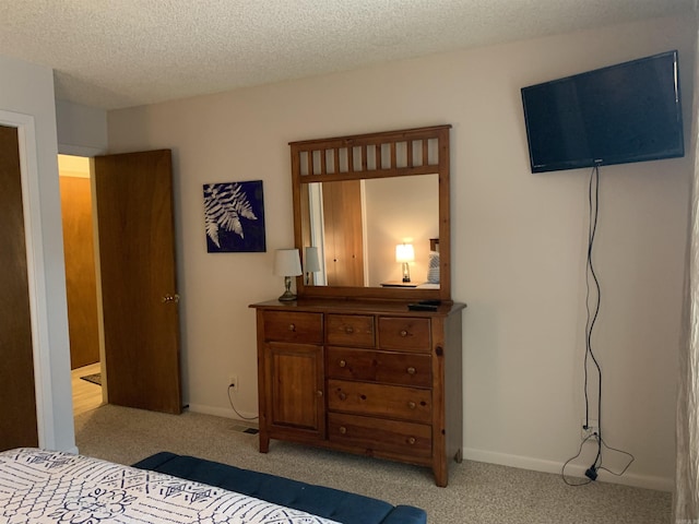 bedroom featuring baseboards, a textured ceiling, and light colored carpet