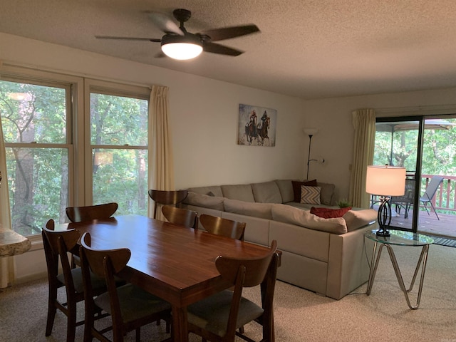 dining area with a textured ceiling, ceiling fan, and light carpet