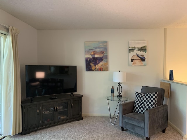 living area featuring light carpet and baseboards