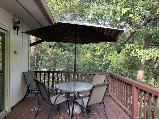 deck featuring a wooded view and outdoor dining space