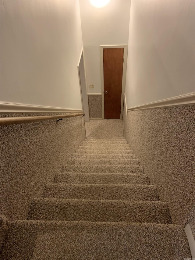 stairs featuring wainscoting