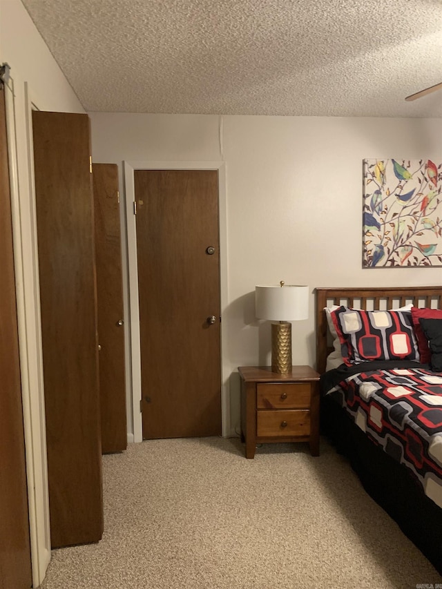 bedroom featuring a textured ceiling and light colored carpet