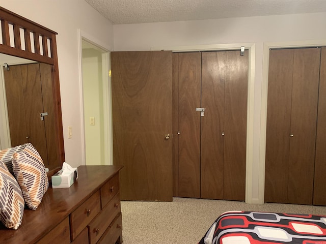 bedroom featuring multiple closets and a textured ceiling