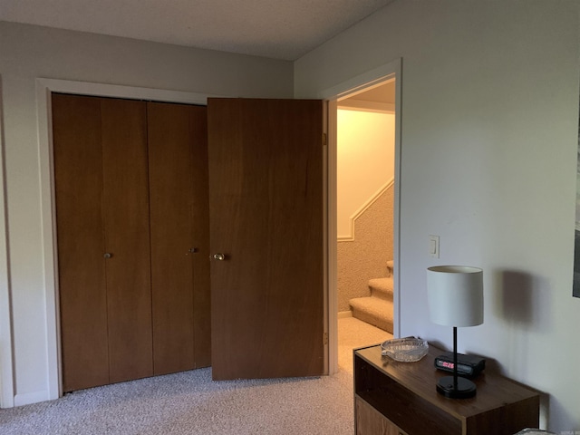 bedroom featuring a closet and light colored carpet