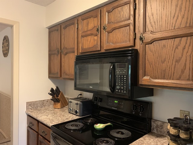 kitchen with brown cabinets, light countertops, and black appliances