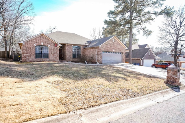 ranch-style house featuring brick siding, driveway, an attached garage, and central air condition unit