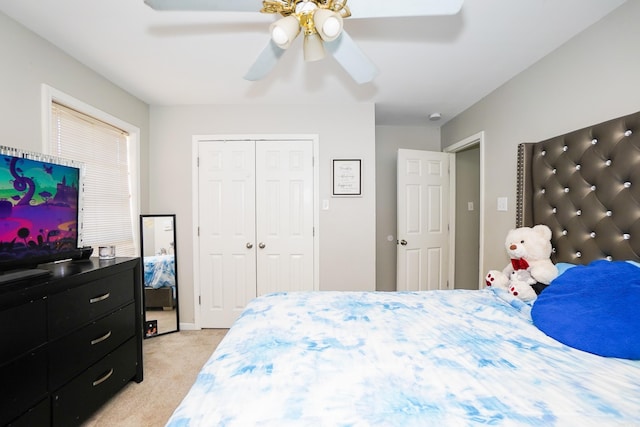 bedroom with a closet, light carpet, and ceiling fan