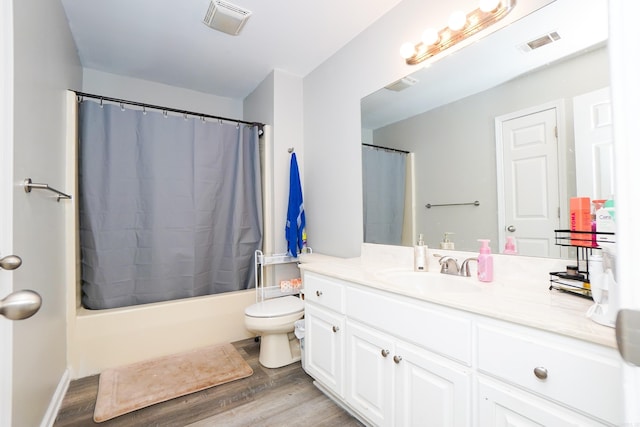 bathroom with toilet, visible vents, wood finished floors, and vanity