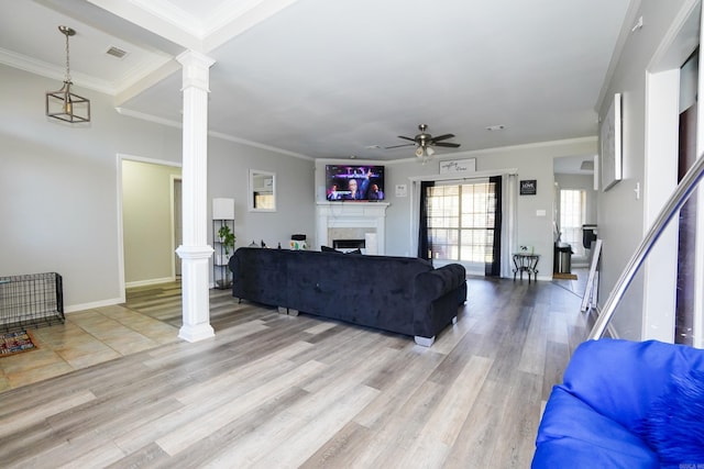 living room with visible vents, light wood-style flooring, and decorative columns