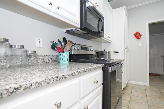 kitchen with light tile patterned floors, electric range, baseboards, white cabinets, and black microwave