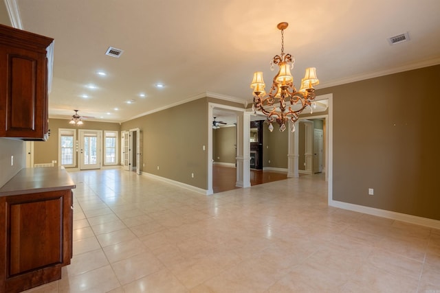 empty room featuring ornamental molding, visible vents, baseboards, and ceiling fan with notable chandelier