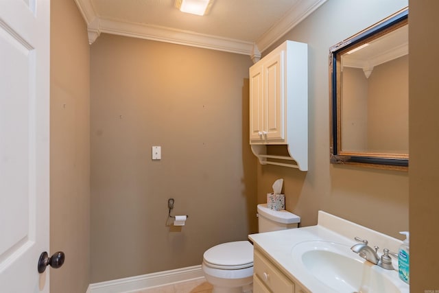 bathroom featuring toilet, baseboards, crown molding, and vanity
