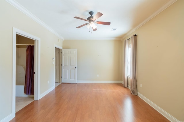 spare room with baseboards, ornamental molding, visible vents, and light wood-style floors