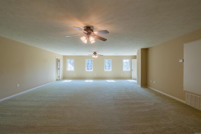 spare room with light carpet, baseboards, visible vents, and a textured ceiling