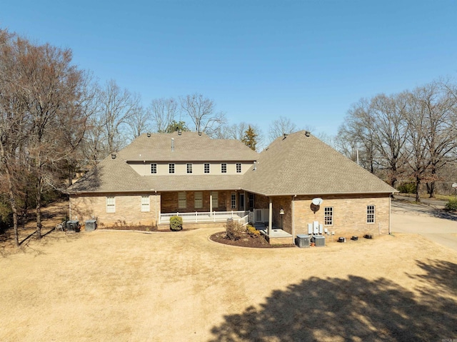 back of property with covered porch and dirt driveway