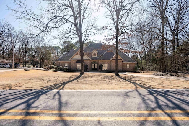 french country inspired facade featuring brick siding