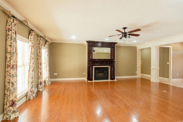unfurnished living room with a fireplace with flush hearth, a wealth of natural light, decorative columns, and light wood-style flooring