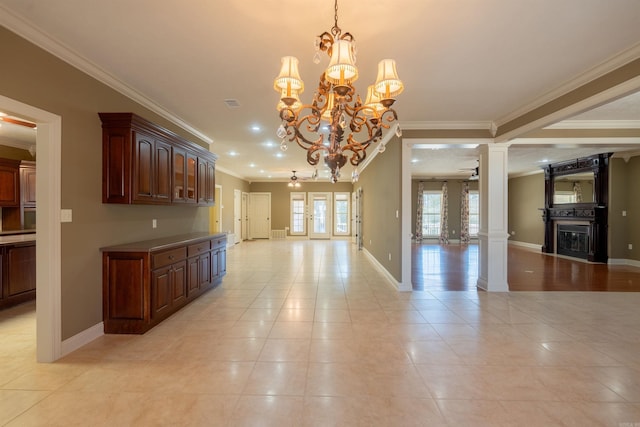 interior space with ornate columns, baseboards, open floor plan, and ceiling fan with notable chandelier