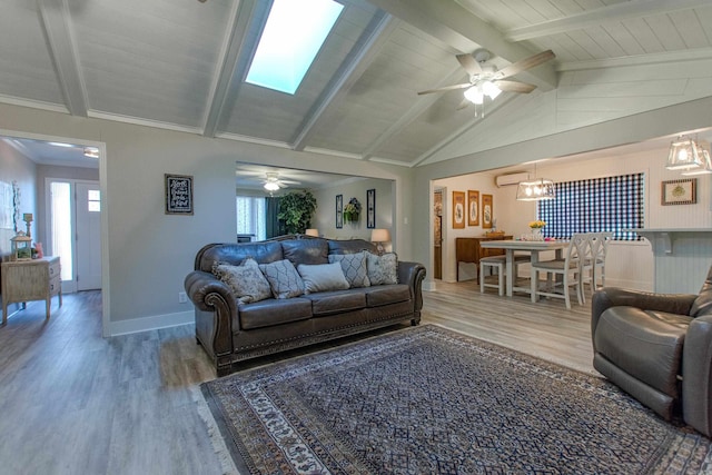 living room featuring a wealth of natural light, lofted ceiling with beams, and wood finished floors