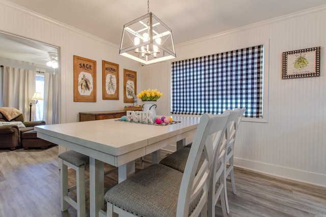 dining room with baseboards, light wood-style floors, ceiling fan with notable chandelier, and crown molding