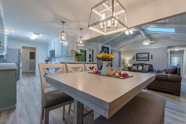 dining room featuring lofted ceiling with beams, ceiling fan, and light wood finished floors