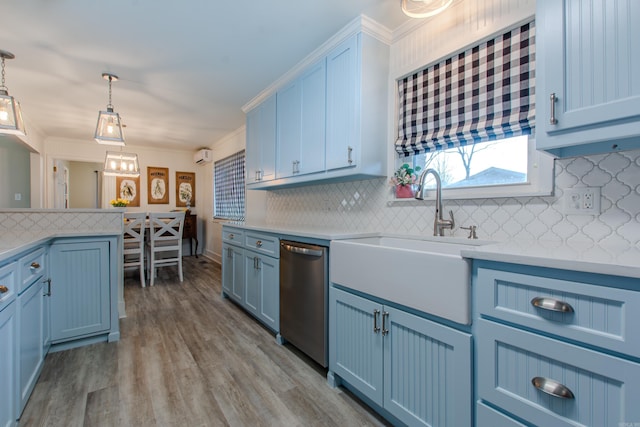 kitchen with dishwasher, light countertops, blue cabinetry, and a sink