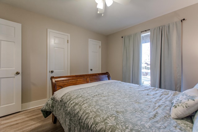 bedroom with ceiling fan, baseboards, and wood finished floors