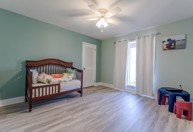 bedroom featuring a closet, ceiling fan, baseboards, and wood finished floors