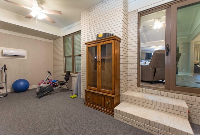 workout area with a ceiling fan, carpet, brick wall, and a wall mounted AC