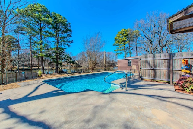 view of pool featuring an outbuilding, a patio area, fence, and a fenced in pool