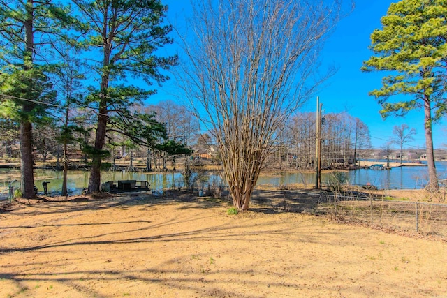 view of yard with a water view and fence