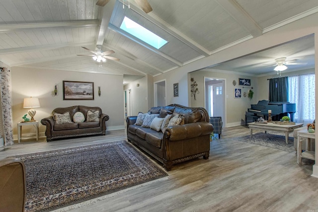 living area featuring a ceiling fan, wood ceiling, wood finished floors, vaulted ceiling with skylight, and baseboards