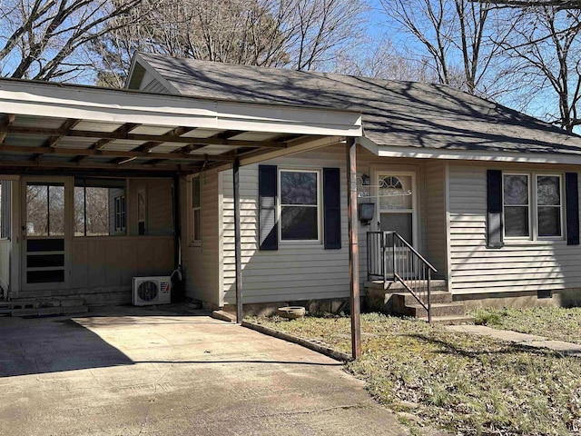 view of front of home featuring driveway, an attached carport, roof with shingles, crawl space, and ac unit