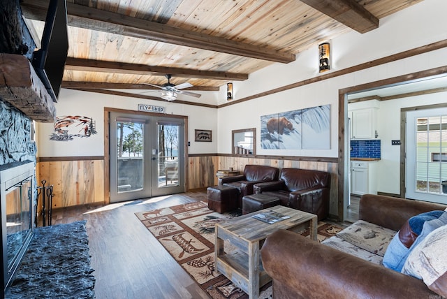 living room with wainscoting, wooden ceiling, wood finished floors, french doors, and beam ceiling