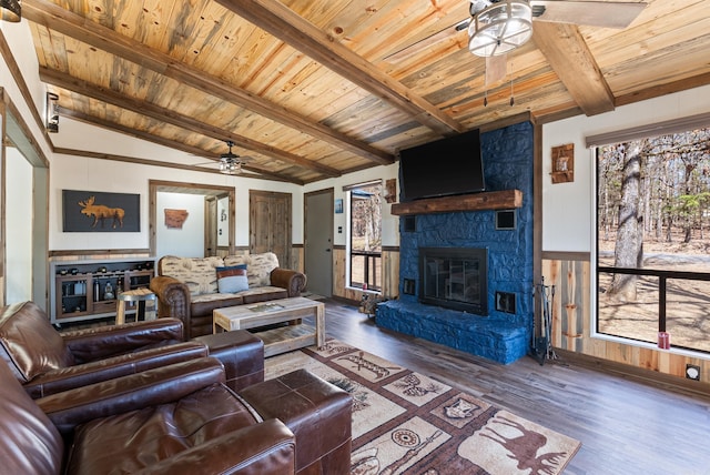 living room with wood ceiling, a stone fireplace, lofted ceiling with beams, and wood finished floors