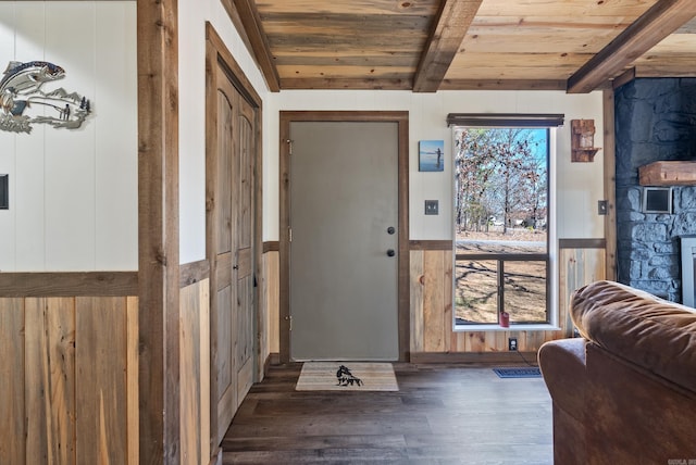 entrance foyer with wooden ceiling, a wainscoted wall, beam ceiling, and wood finished floors