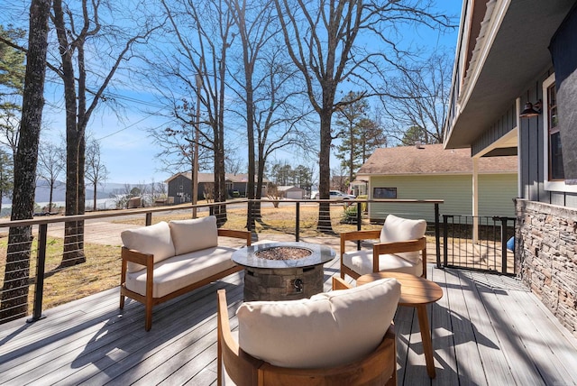 wooden terrace with an outdoor living space with a fire pit