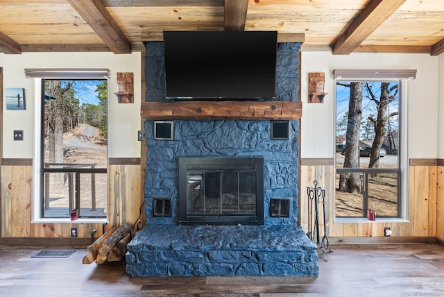 interior details featuring a stone fireplace, wooden ceiling, wood finished floors, and beam ceiling