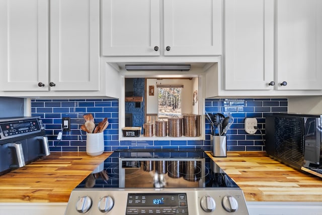 kitchen with white cabinets, tasteful backsplash, wooden counters, and electric stove